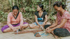 Bali villagers sitting and weaving Wanderer bracelets